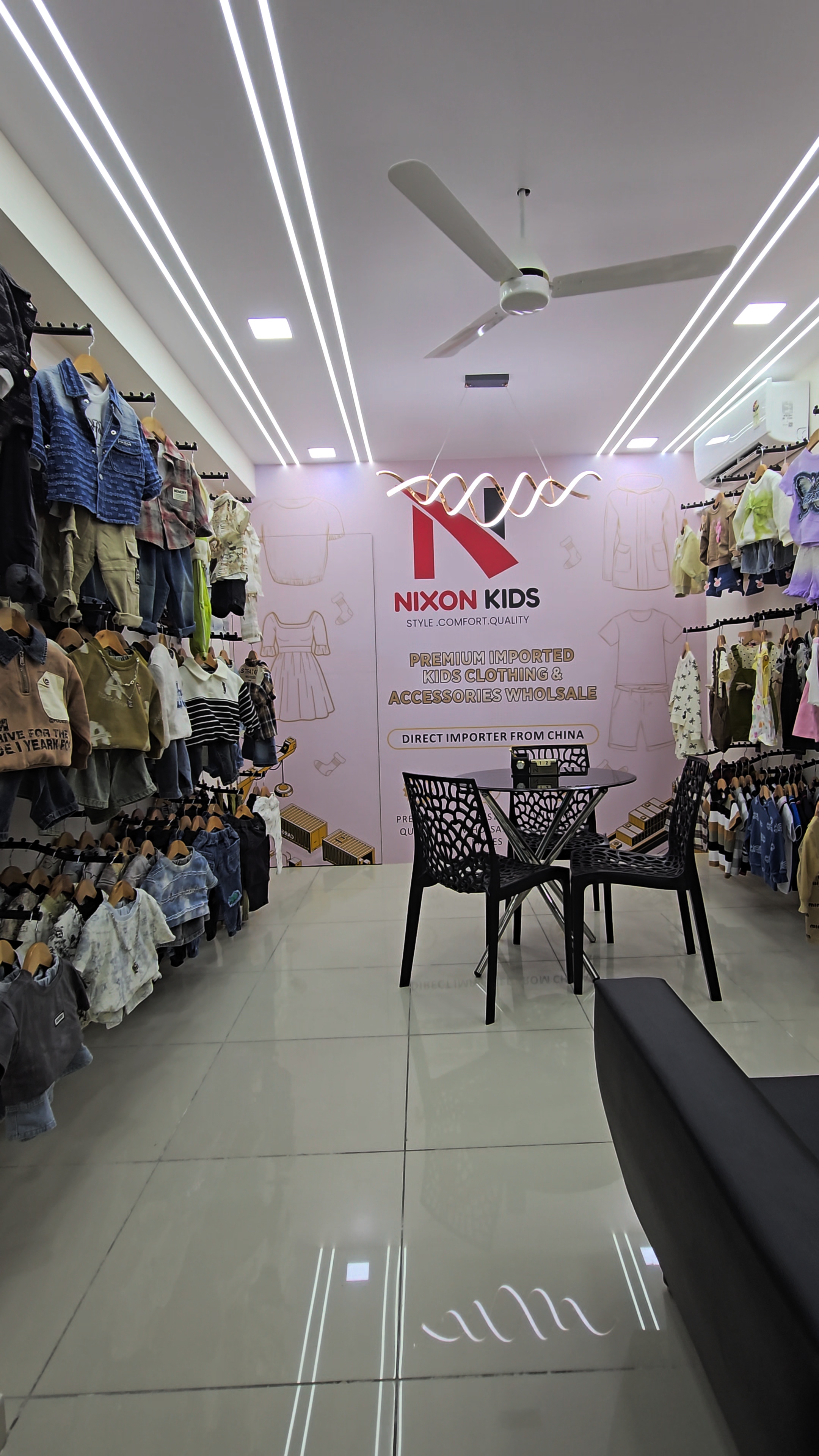 Inside the Nixon Kids wholesale showroom in Ahmedabad, with racks of imported kids clothing on both walls.